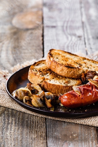 Grilled sausage, toasts and mushrooms