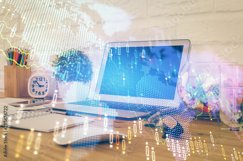 Financial graph colorful drawing and table with computer on background. Multi exposure. Concept of international markets.