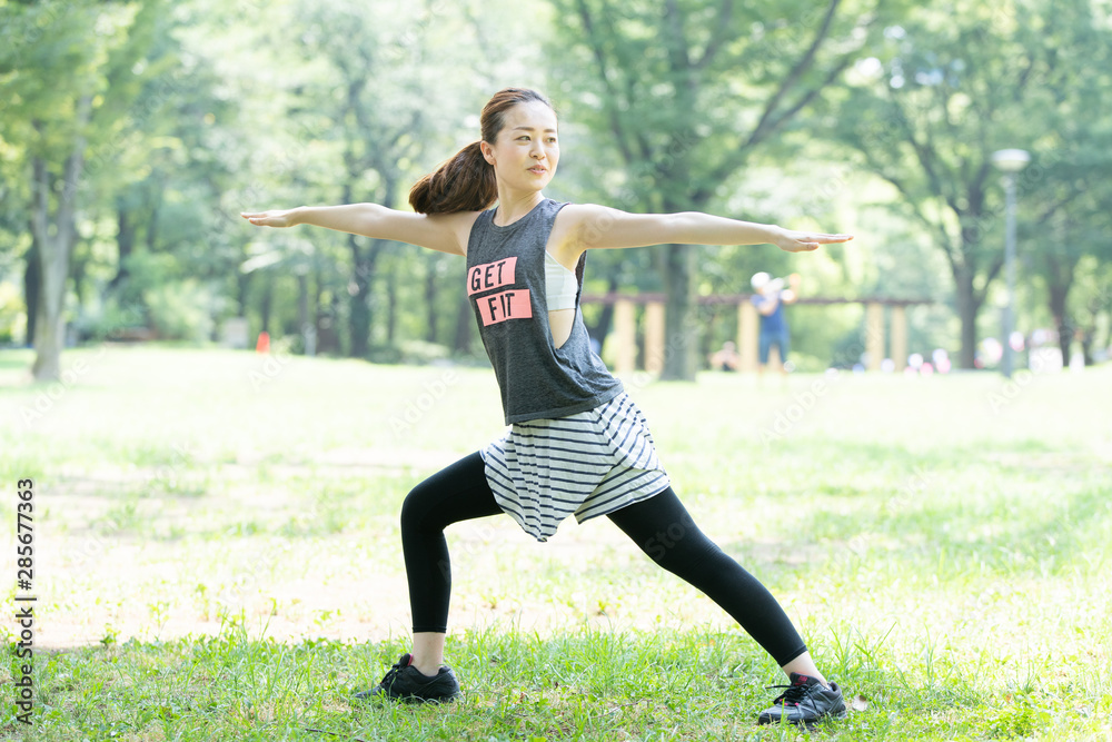 公園でヨガ・ストレッチをする女性 公園でヨガ・ストレッチをする女性