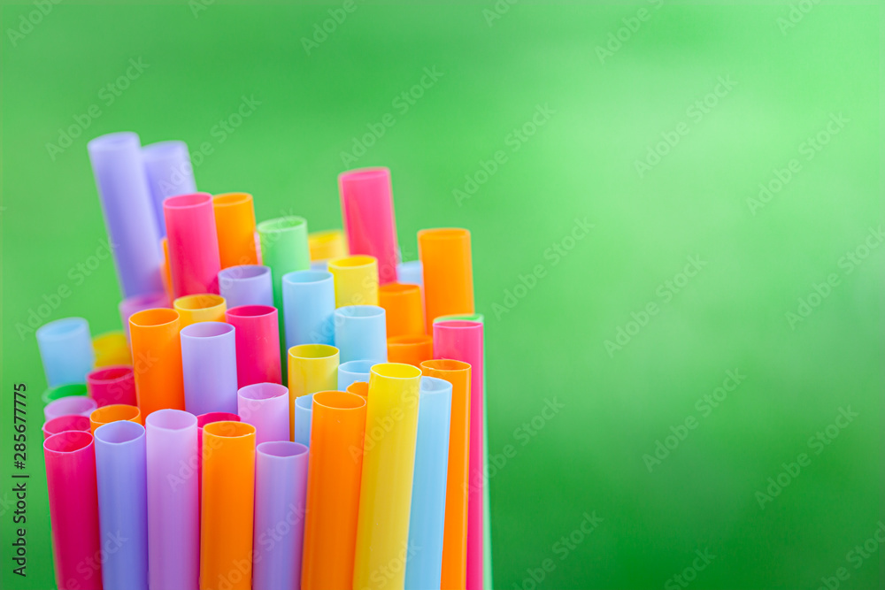 Multiple color drinking straws on a green grass background blur Multiple color drinking straws on a green grass background blur