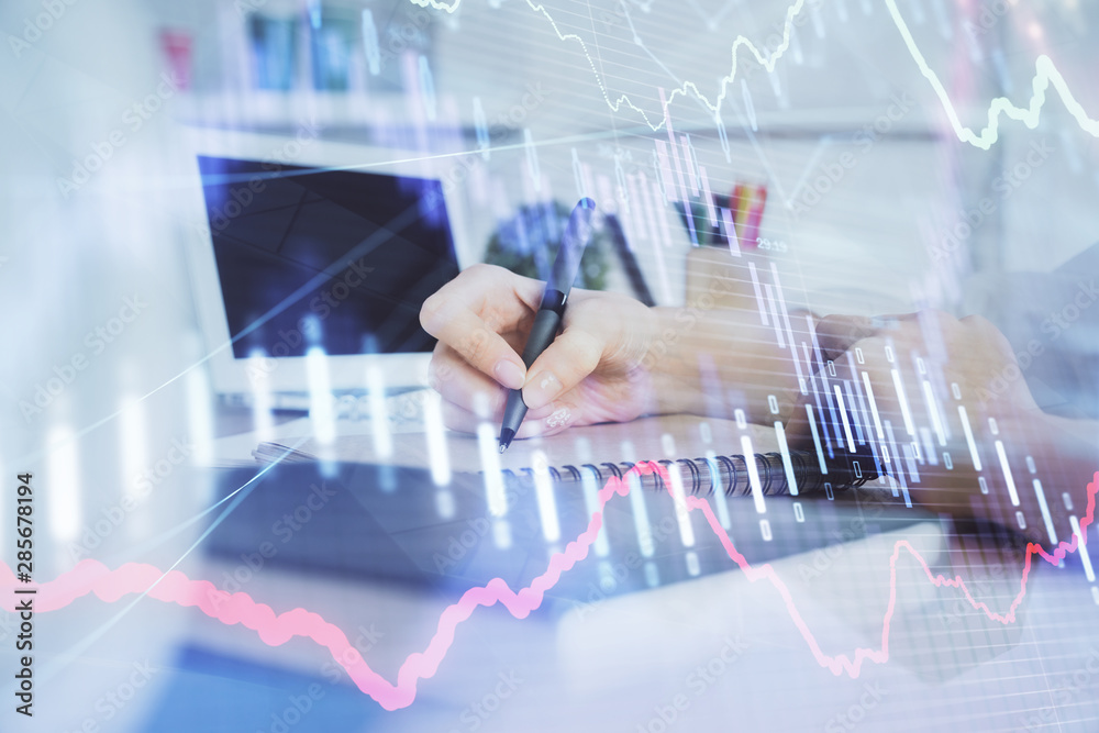 Financial graph displayed on woman's hand taking notes background. Concept of research. Double exposure Financial graph displayed on woman's hand taking notes background. Concept of research. Double exposure