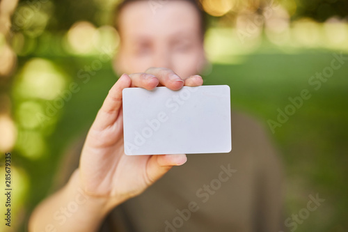 Girl holding a white credit card in her hands for shopping. 