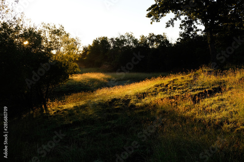 Fall Texas landscape shows sunrise over hills in rural countryside.