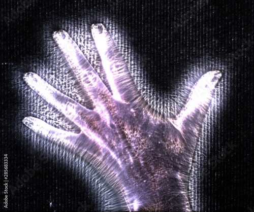 3D-Illustration of a glowing human female hand with a kirlian aura showing different symbols photo