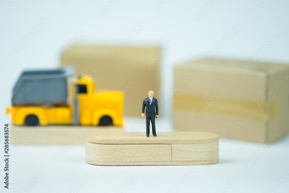 Miniature people businessman standing in front of warehouse for investment analysis in shipping. Miniature people businessman standing in front of warehouse for investment analysis in shipping.