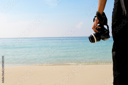 Photographer with camera Traveling backpacker of sea water and sand on the beach in tropical island with carefree and relaxing attitude - Travel Concept.