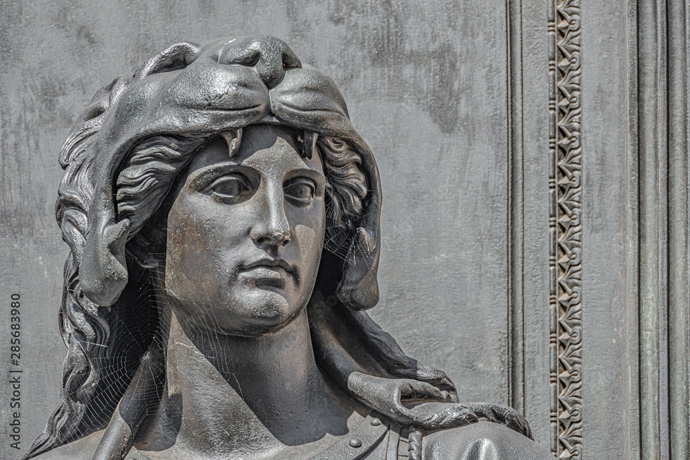 Fototapeta premium Old statue of a sensual woman warrior as defender with lion head and club at the Neumarkt in downtown of Dresden, Germany, details, closeup