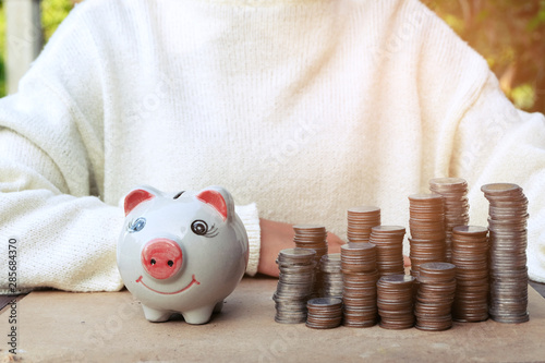 Scattered coins in the wooden backgroundpiggy bank, Hands of business, Concept of saving money for future. photo