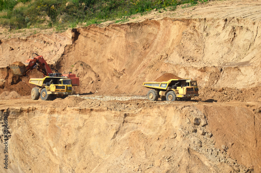Excavator developing the sand on the opencast and loading it to the heavy dump truck. Processing of loose material in mining quarry. Drill, breaking, processing plant, crushing and screening - Image Excavator developing the sand on the opencast and loading it to the heavy dump truck. Processing of loose material in mining quarry. Drill, breaking, processing plant, crushing and screening - Image