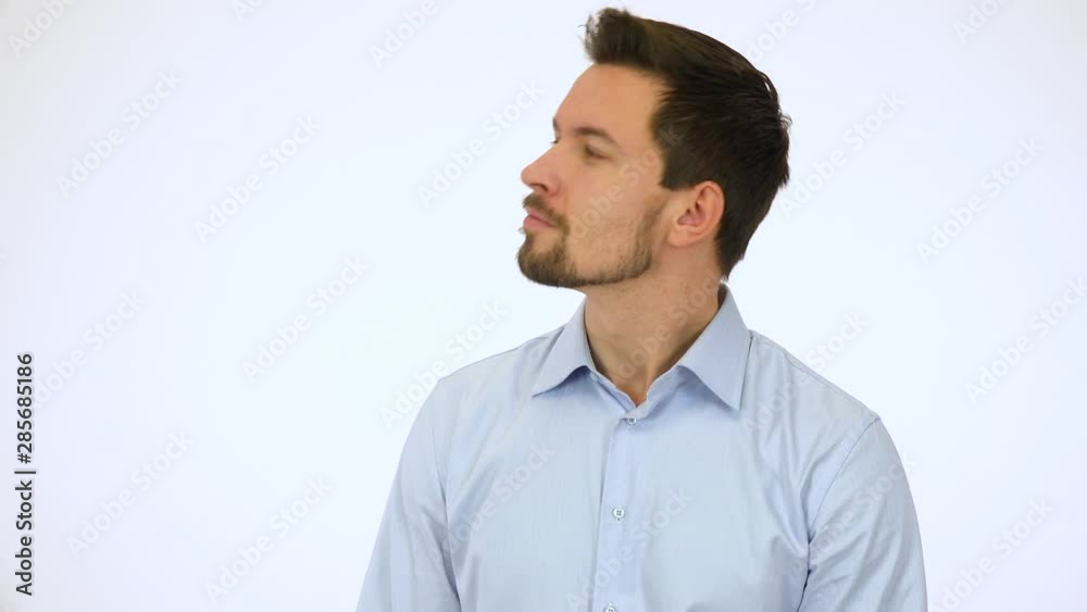 A young handsome man looks around with a smile - white screen studio A young handsome man looks around with a smile - white screen studio