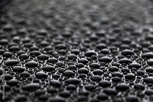 Fotografie, Obraz hundreds and thousands of water droplets beading on a gloss black surface of a w