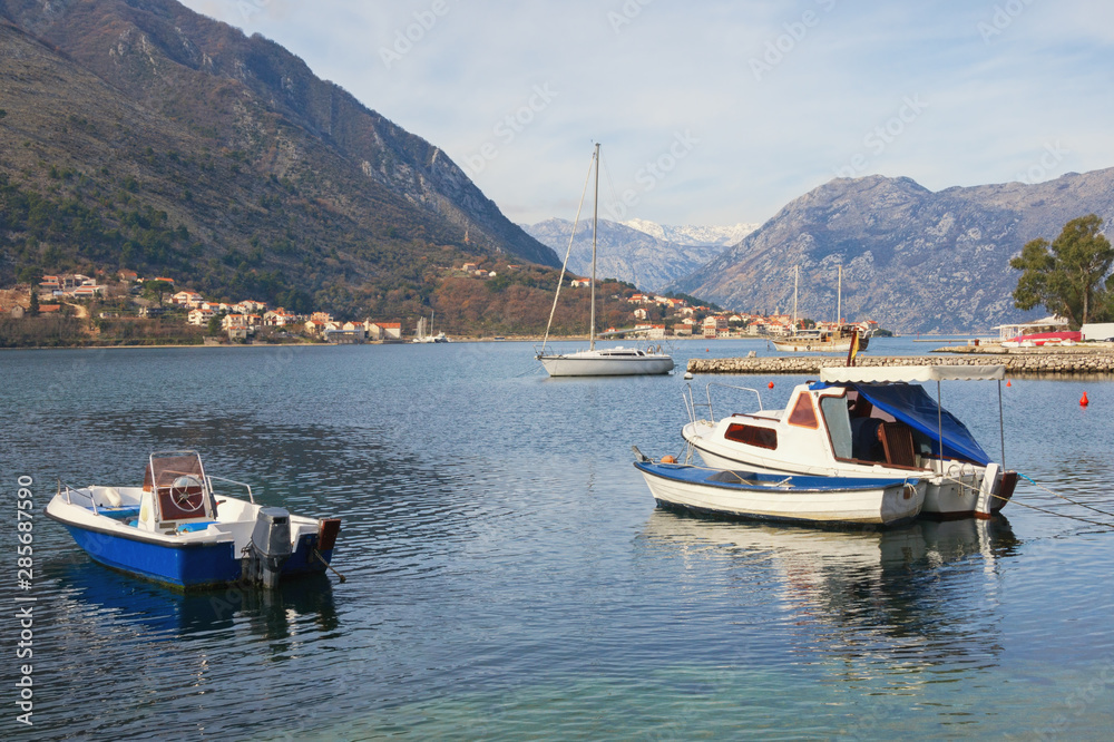 Beautiful winter Mediterranean landscape with fishing boats on the water. Montenegro, Adriatic Sea. View of Bay of Kotor near Kotor city
