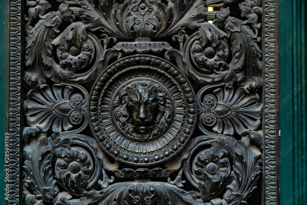Door knocker with lion. wooden door lion lock. Decorative door handle in form of bronze lion head on old wooden entrance door