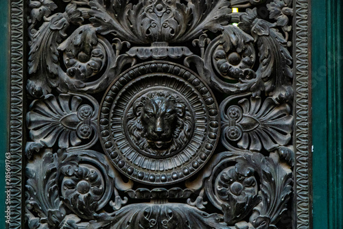 Door knocker with lion. wooden door lion lock. Decorative door handle in form of bronze lion head on old wooden entrance door