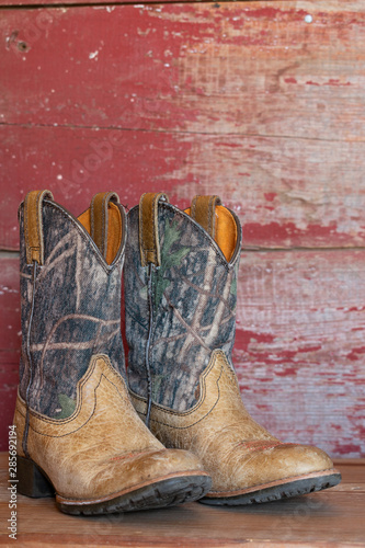 camouflage cowboy boots with red barn board background