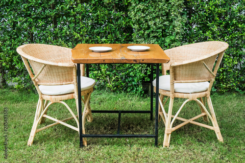 Wooden dining tables in lush garden