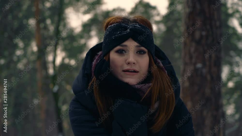 close-up portrait of a funny red ginger hair girl in a snowy park. girl indulges and flirts with the camera 4K close-up portrait of a funny red ginger hair girl in a snowy park. girl indulges and flirts with the camera 4K