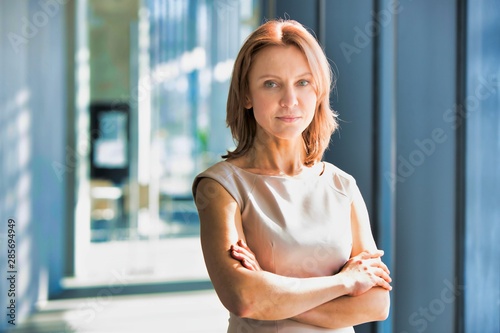 Free Download Mature confident businesswoman standing in office hall - GFXLoad