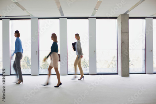 Business people walking in office corridor