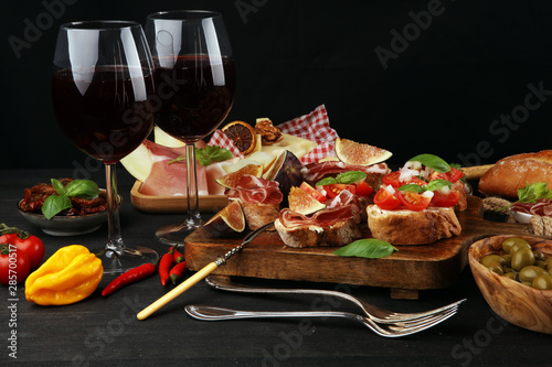 Italian antipasti wine snacks set. Cheese variety, Mediterranean olives, Prosciutto di Parma, tomatoes, artichokes
