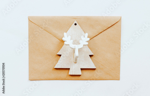  brown paper envelope and a Christmas tree toy with a deer head on a white isolated background. photo