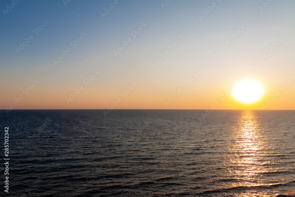 Naklejka premium Evening sunset on the sea. The sun almost touched the horizon.