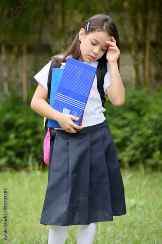 Depressed Female Student Wearing Uniform With Books