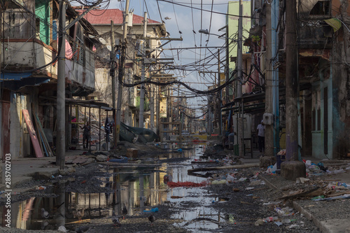 Photograph of an alley where there is stagnant water, garbage and precarious conditions for life. Poverty and inequality concept © Joseph De Frías