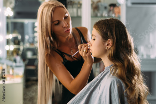 Foto Professional expert,makeup artist prepares very beautiful,young,well-known,glamo