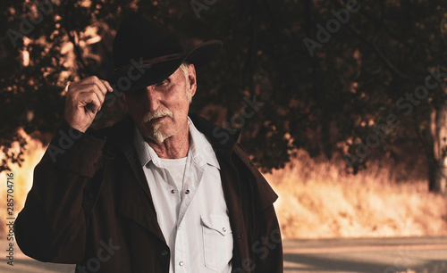 Tablou pe pânză Older Cowboy Tips Hat