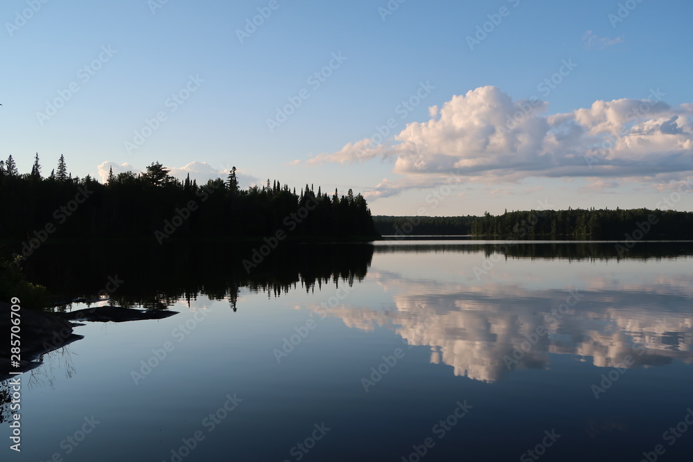 Fototapeta premium Rain Lake, Algonquin Provincial Park, Canada (still lake reflection at sunset with trees and clouds)
