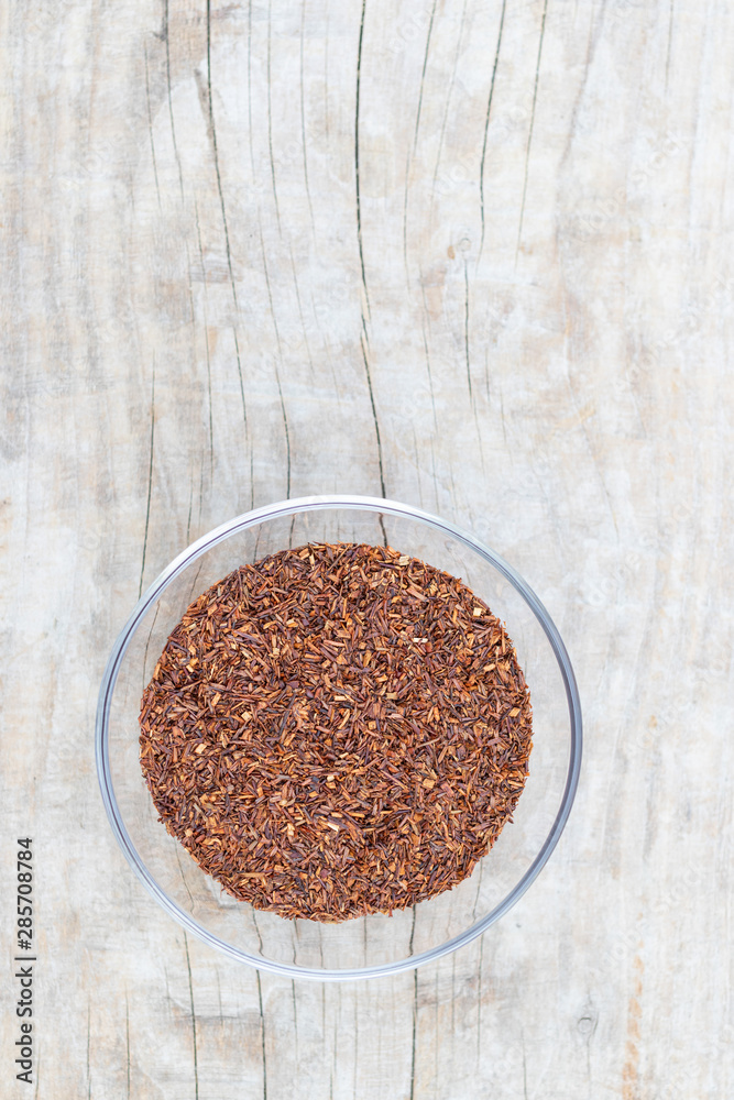 Loose tea rooibos superior in a glass cup on a wooden background Loose tea rooibos superior in a glass cup on a wooden background