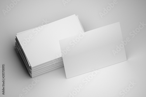 Blank mock up of stack of white business cards with one standing card on white background. 3d illustration. photo