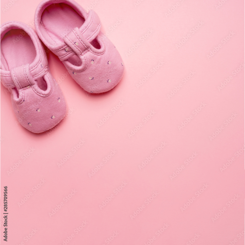 Baby textile Slippers for girl on pink background with copy space.