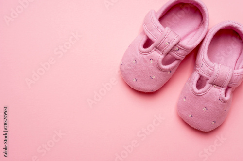 Baby textile Slippers for girl on pink background with copy space.