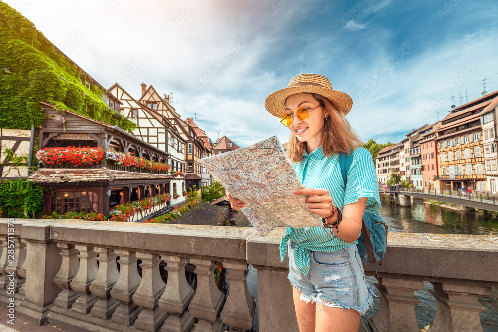 Happy asian female tourist with map searching for travel location in European old town