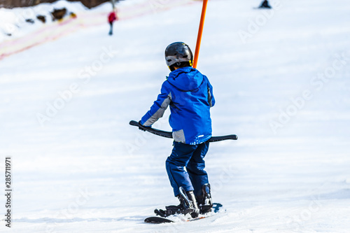 children on a ski lift, ski-lift and snow-capped mountains.