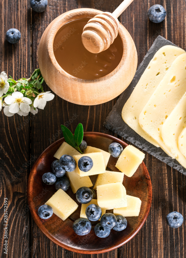 cheese with blueberries on a wooden background cheese with blueberries on a wooden background