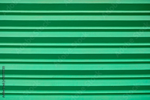 Horizontal stripes in dark and light green tones.