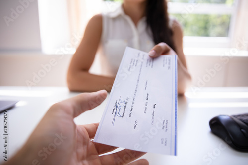 Konstfotografi Businesswoman Giving Cheque To Colleague