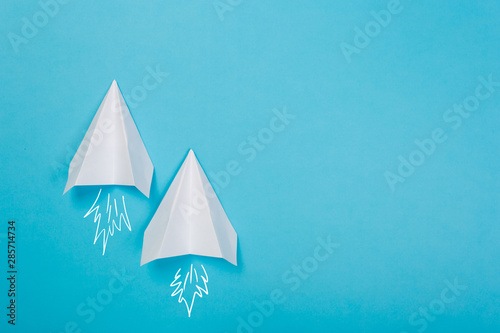 white paper airplane on a navy paper background