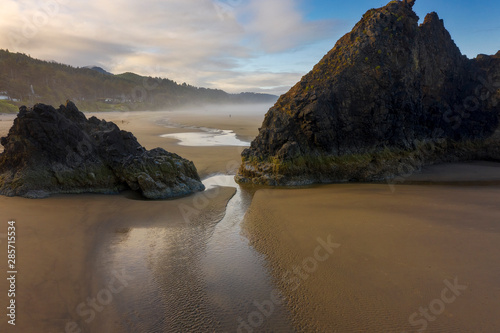 Dramatic Rock Outcroppings At The Oregon Coast. Lava flows created many of the Oregon coasts natural features, including Tillamook Head, Arch Cape, and Saddle Mountain. Morning light adds a warm glow.