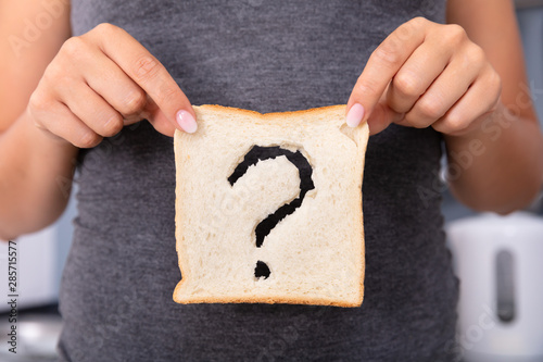 Картината върху платно Woman Holding Slice Of Bread With Question Mark Sign