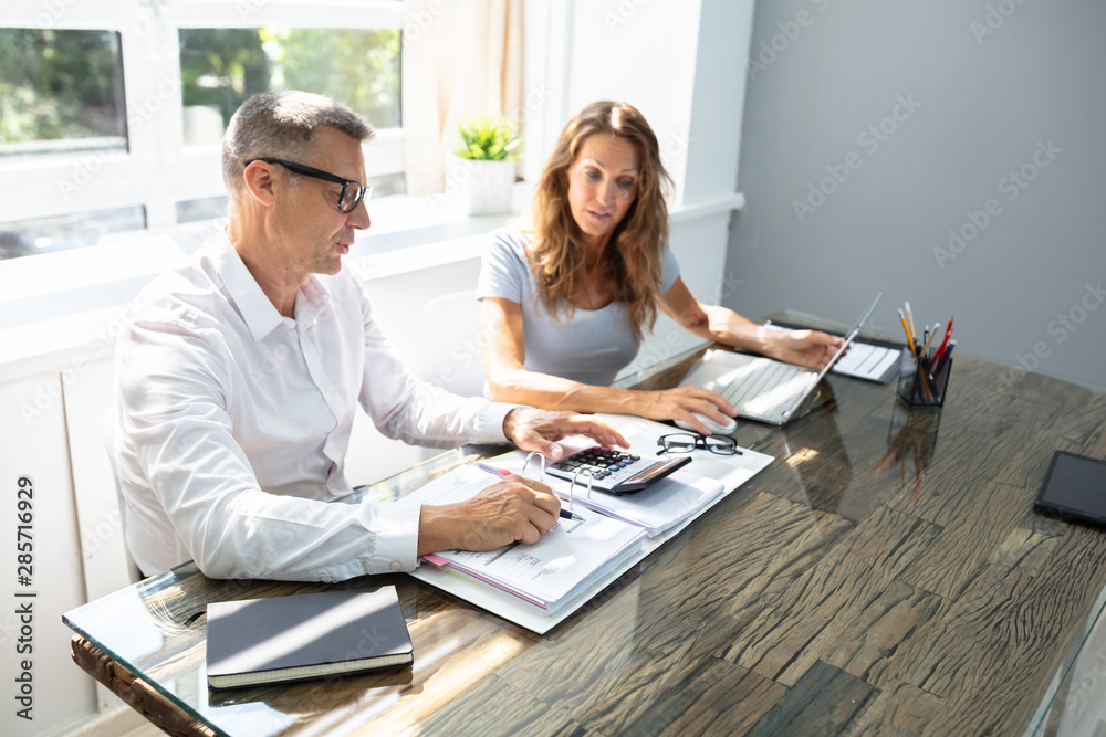 Obraz premium Two Worker Calculating Report In Office