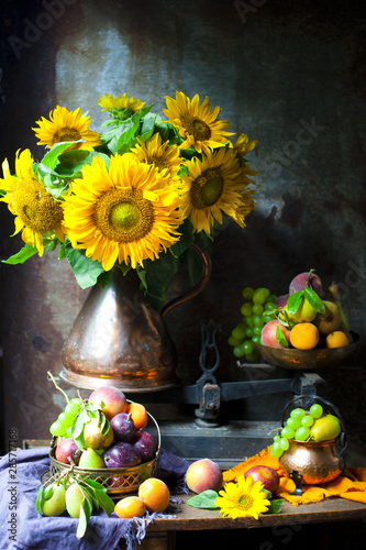 Still life with sunflowers and fruits on an old background