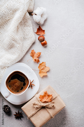 Autumn composition. Cup of coffee, white knitted plaid on stone background. Fall concept. Flat lay, top view, copy space