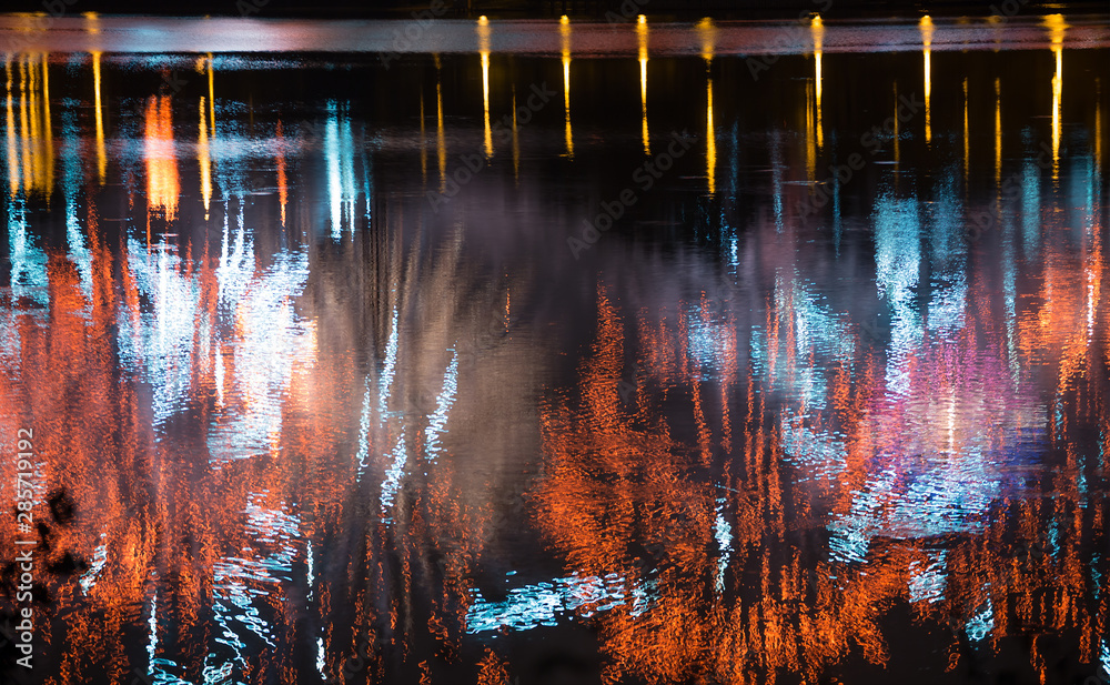 Beautiful fireworks over the city with reflection in the water, closeup and bokeh, blur effect, yellow