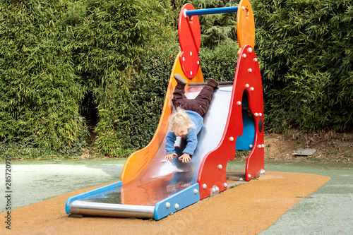 Φωτογραφία Enfant descend du toboggan la tête en bas