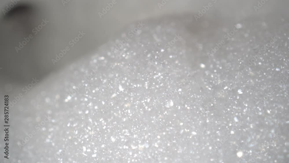 A pile of foam moves on a wave in the bathroom. A stream of water in the background. Preparation for washing A pile of foam moves on a wave in the bathroom. A stream of water in the background. Preparation for washing