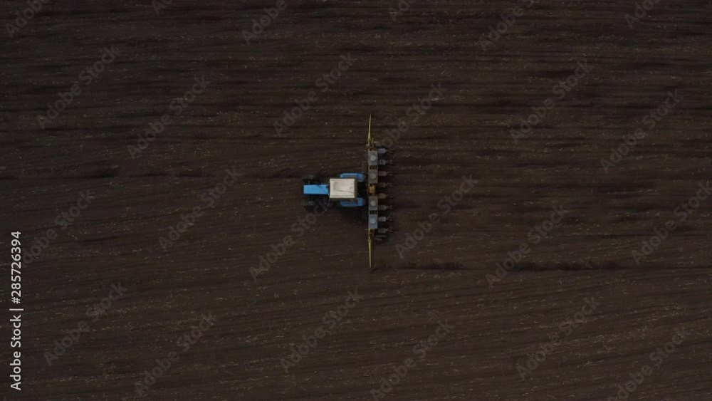 Top view of farm machine plowing the black earth drone footage Top view of farm machine plowing the black earth drone footage
